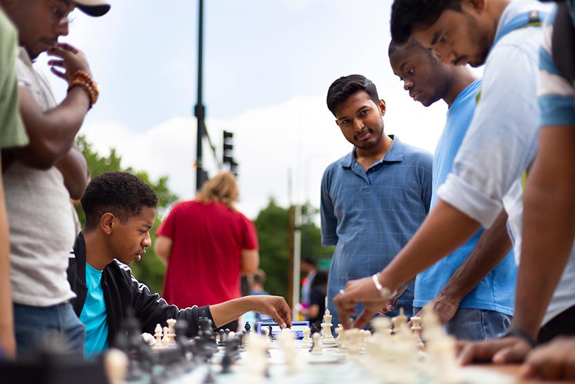 Students outside playing chess