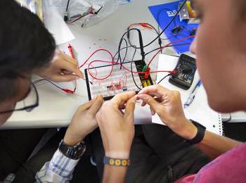 Students work on a circuitboard together