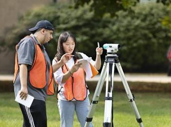 Civil Engineering - photo of students outdoors with a transit on a tripod
