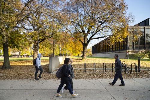 Outdoor photo of students walking on campus in autumn, showing Galvin library