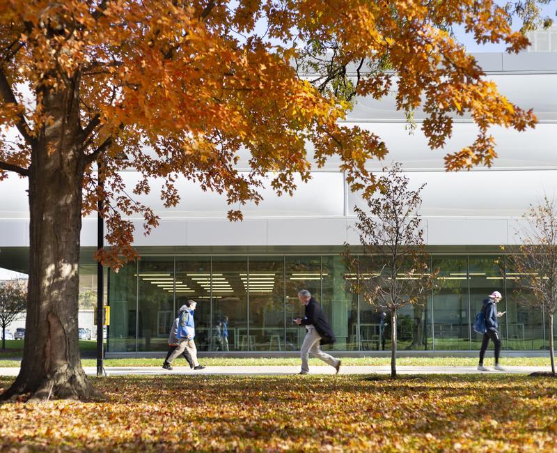 Students walk by the Kaplan Institute on a fall day