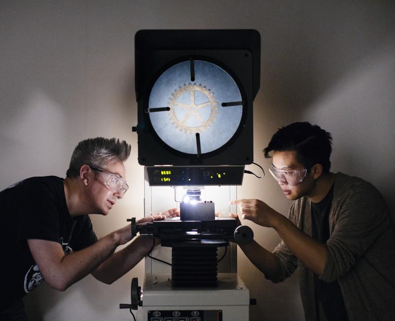 Two students examine a gear in a materials lab